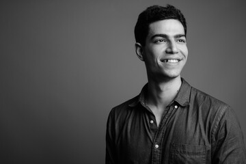 Obraz premium Portrait of happy young handsome Persian businessman thinking