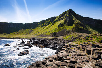 Landscape of Giant's Causeway trail with a blue sky in summer in Northern Ireland, County Antrim. UNESCO heritage. It is an area of basalt columns, the result of an ancient volcanic fissure eruption - obrazy, fototapety, plakaty