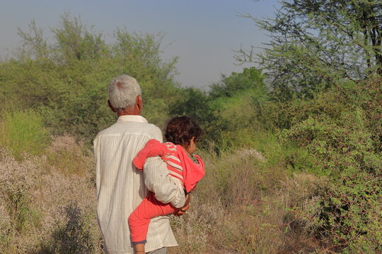 An Indian grandson and grandfather enjoying walking in the forest