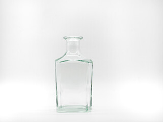 Single empty glass bottle on a white background. Transparent square bottle. Front view of the vertical staying colorless jar.