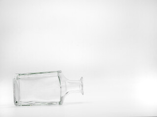Single empty glass bottle on a white background. Transparent square bottle. Front view of the...