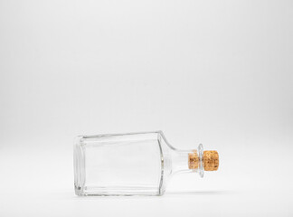 Empty glass bottle closed with cork cap isolated on a white background. Front view of the laying on...