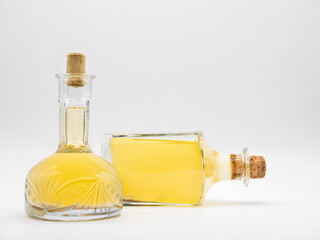 Alcohol drink in upright glass carafe and glass bottle lying on its side closed with cork caps...