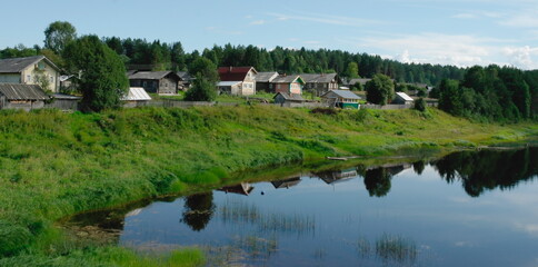 Fototapeta na wymiar village on the river bank in summer