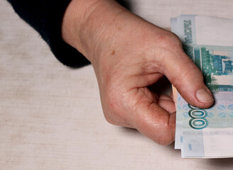 Senior woman counts one thousand rubles bills. Hands and money of the old woman. Old age, retirement savings and investment concept.