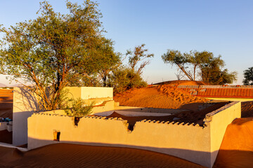 Al Madam ghost town buildings and walls buried in sand dunes in the desert of Sharjah, United Arab...