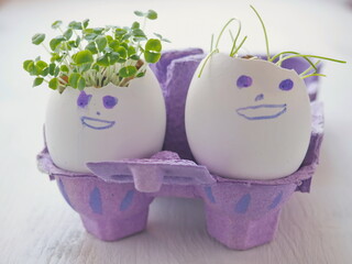 DIY funny eggs-figures as Easter decoration with fresh sprouts as a hairstyle. Easter symbol. Selective focus on the front.