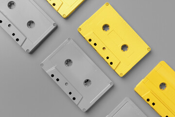 Yellow and gray audio cassettes on gray background top view