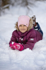 A child girl on a walk in a winter park