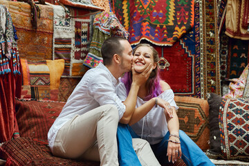 Couple in love chooses a Turkish carpet at the market. Cheerful joyful emotions on the face of a man and a woman. Valentines Day in Turkey