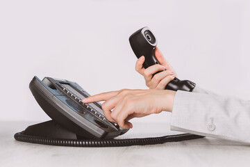 business and communications. Using voip phone in the office, close up of hand with receiver. Conference call, contact us or hotline. IP telephony, Telemarketing. Help desk or call center