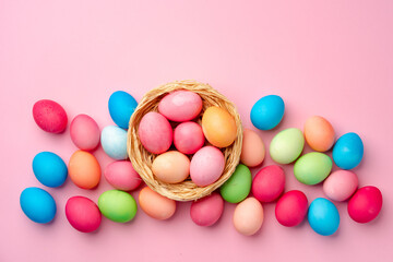 Painted Easter eggs in decorative nest on pink background