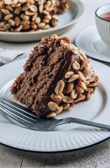 Chocolate cake with caramel cream and peanut on concrete background.