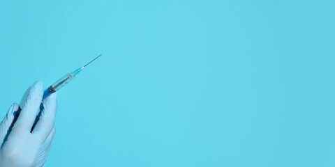 Vaccination concept. Doctor's hand in medical gloves holding a syringe injection. Banner, copy...