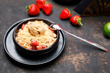 Caramel ice cream on baked fruit. Sweet dessert served in a black bowl. Suggestion to serve the dish.