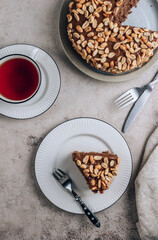 Chocolate cake with caramel cream and peanut on concrete background.