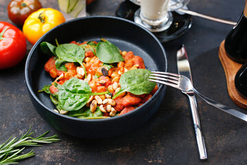Tomatoes baked with spinach and peanuts.
Food served on a plate, food styling, serving suggestions, culinary photography.