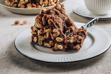 Chocolate cake with caramel cream and peanut on concrete background.