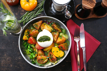
Mozzarella with green pesto served with colorful tomatoes on spinach leaves. A colorful, healthy breakfast.
Food served on a plate, food styling, serving suggestions, culinary photography.