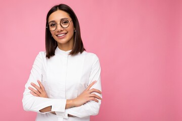 Fototapeta premium Photo shot of beautiful smiling young brunette woman wearing casual clothes and stylish optical glasses isolated over colorful background looking at camera