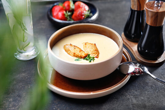Cream soup with white vegetables with baked potatoes.
Food served on a plate, food styling, serving suggestions, culinary photography.
