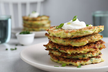 Delicious zucchini fritters served on light table indoors, closeup