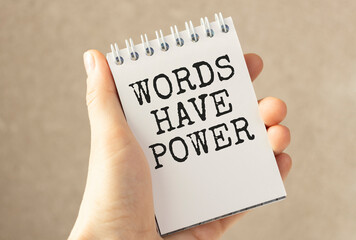 Words have power - inspirational handwriting in a notebook on wooden table with pen, crumpled paper and paper clips, communication and influence concept