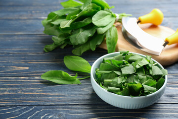Fresh cut sorrel leaves on blue wooden table, closeup