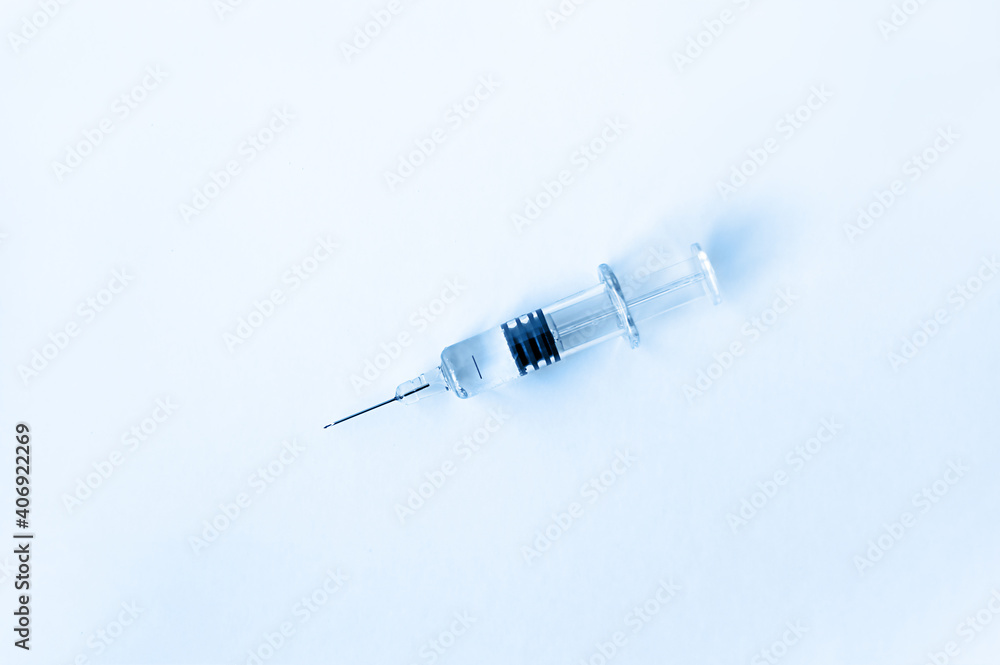 Wall mural on the table lies a syringe with a needle for medical vaccination on a blue background. medicine or 