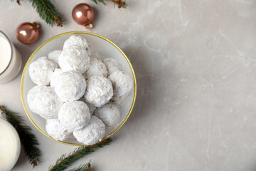 Flat lay composition with Christmas snowball cookies in bowl on light table, space for text