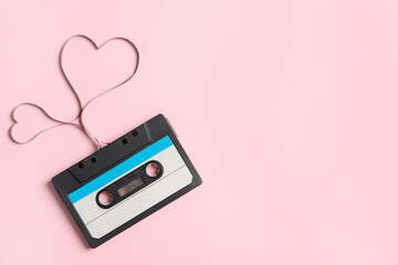 Top view of music cassette and hearts made with tape on pink background, space for text. Listening...