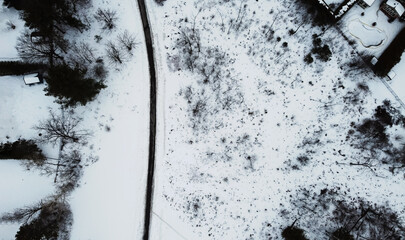 Aerial top view of a winding foot path in winter, between backyards, , surrounded by snow. Ottawa, Ontario, Canada