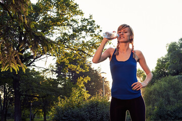 Sporty woman making pause after exercising in the park.