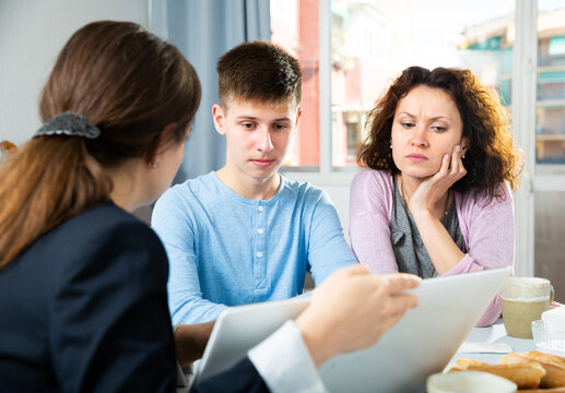 Positive Woman With Teenager Boy Discussing Documents With Financial Adviser