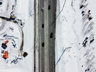 Aerial top view of a road in Kanata, Ottawa, surrounded by snow. Construction on one side, park in another. Ottawa, Ontario, Canada