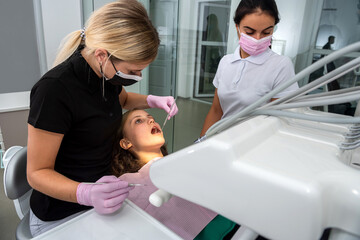 Obraz premium female dentist preparing for dental exam young woman patient