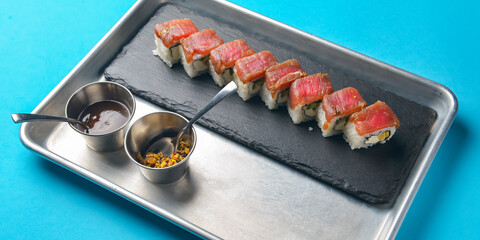 Sushi Set: sashimi and sushi rolls on blue background. Traditional Japanese cuisine concept, close up.
