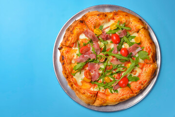 A Pepperoni pizza on a blue background isolated. Traditional Italian cuisine concept, pizza Margarita or Margherita