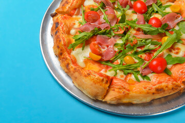 A Pepperoni pizza on a blue background isolated. Traditional Italian cuisine concept, pizza Margarita or Margherita