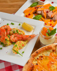 Italian cuisine concept flat lay, top view. Persimmon dishes menu, pizza, shrimps, salad, dessert.