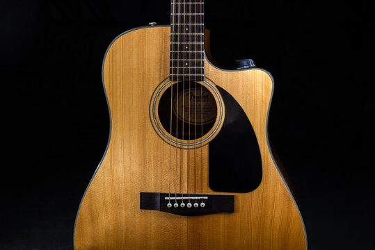 classic acoustic six-string guitar Fender CD-60  with a yellow sound board and black scratchplate on isolated black background