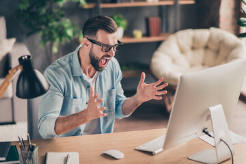 Photo portrait of guy screaming at computer screen on table in modern industrial office indoors
