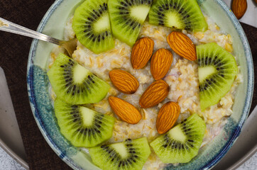 Healthy food for breakfast top view flat lay. Oatmeal porridge, kiwi and almond nuts