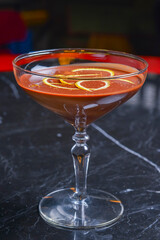 Chocolate cocktail with lemon slices in tall glass on a black table. Eating out in restaurant concept.