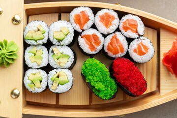 Set of maki sushi on wooden boat tray