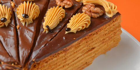 Chocolate cake with icing on top and with nuts over colorful background