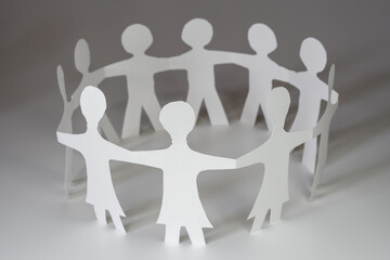 closeup of chain of paper people cut, on white background