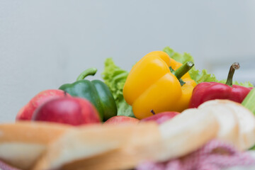 slices bread and vegetable in a tray of red and white checker table cloth.