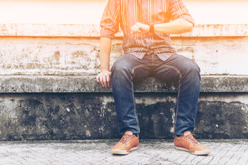 Man look at times and sitting on outdoor grandstand.