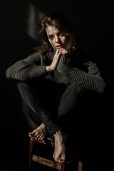 Sensual portrait of beautiful woman in sun light. Dark background 